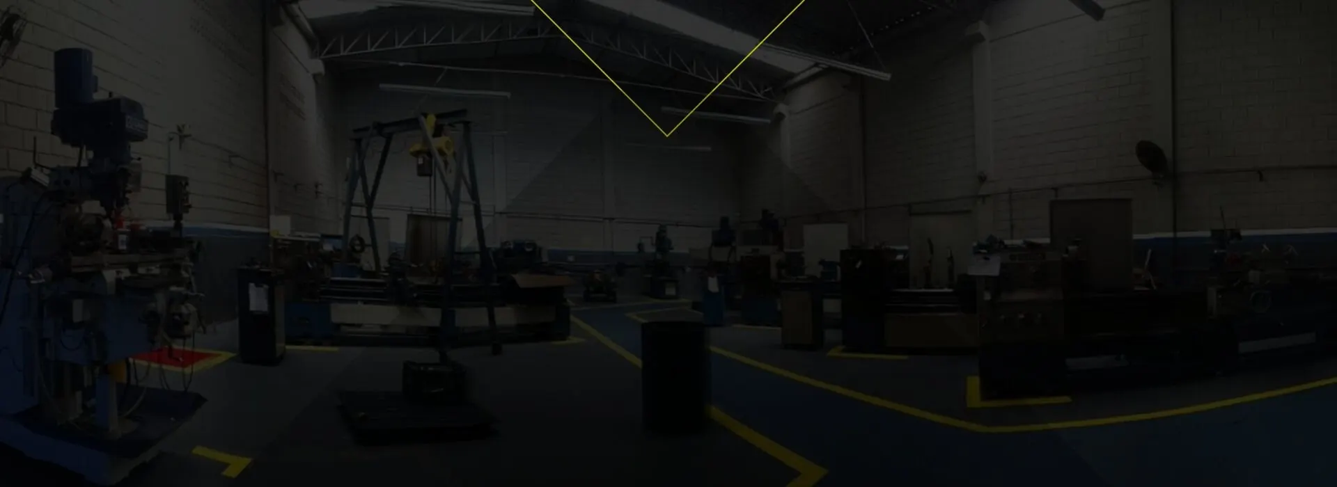 Galpão da Tecnicron com tornos, fresadora e pórtico de içamento, piso com faixas amarelas de segurança